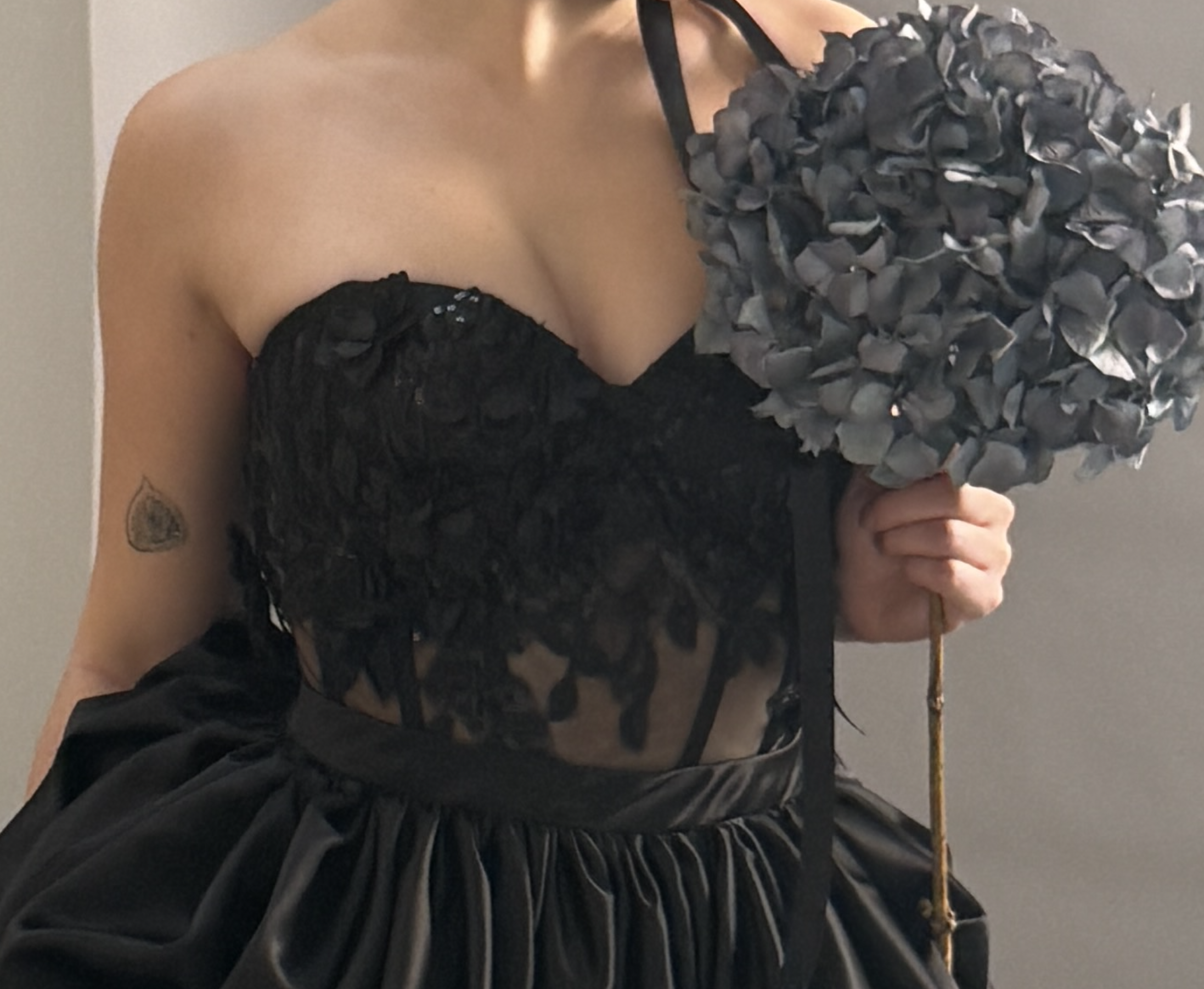 Model trägt ein schwarzes Spitzenkorsett mit Paillettenapplikationen und transparentem Mesh von DEFONDO.