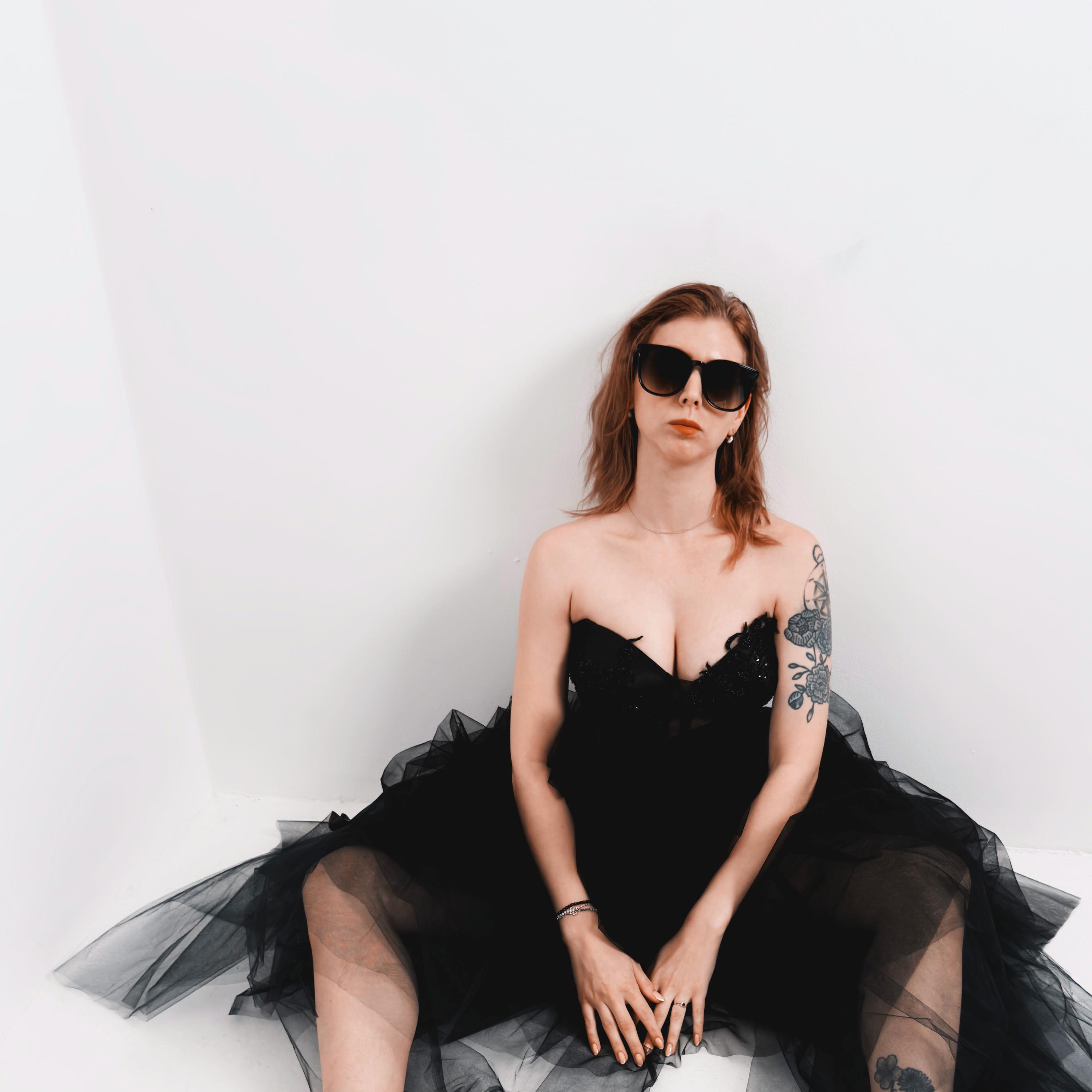 sitzendes Model mit spitzzulaufender schwarzem korsett mit perlen und pailetten stickerei und tuell rock
