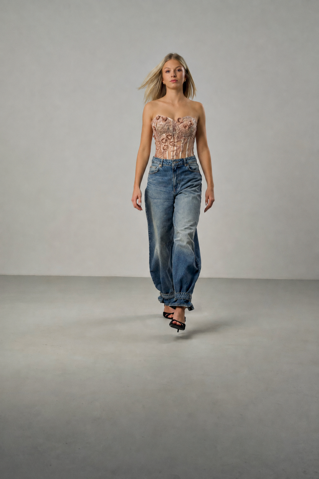 Spitzenkorsett mit floraler Stickerei in Champagner und blauer Jeans, fotografiert im minimalistischen Studio.