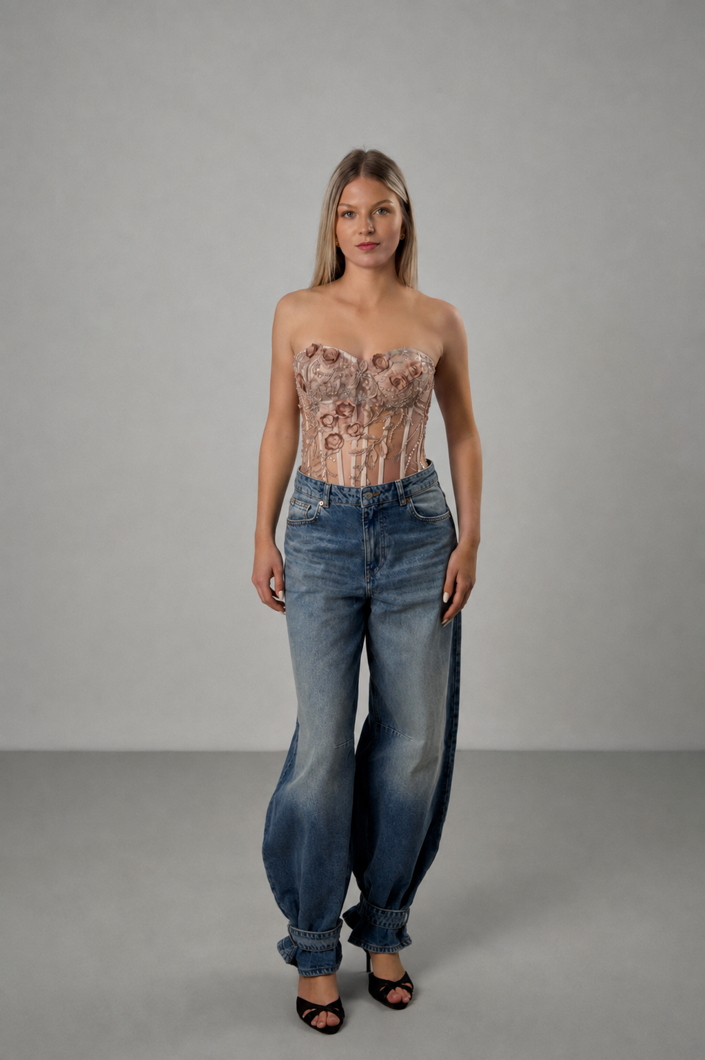Spitzenkorsett mit floraler Stickerei in Champagner, kombiniert mit einer blauen Jeans, Ganzkörperansicht.